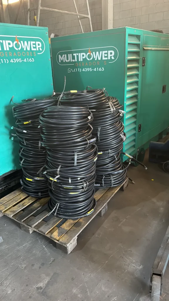 Cabos elétricos enrolados sobre pallet junto a geradores da MultiPower.