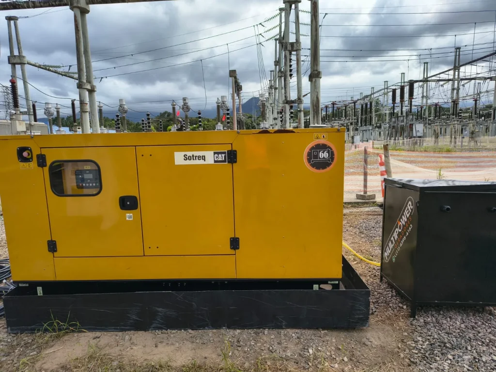 Gerador amarelo instalado em área de subestação elétrica.