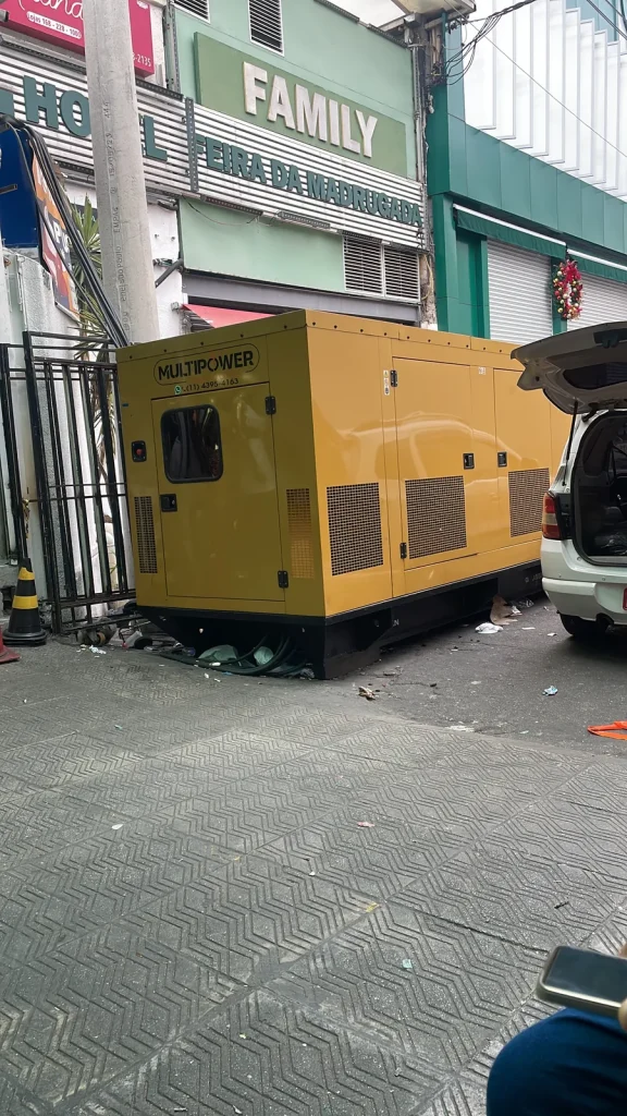 Gerador amarelo instalado junto a entrada de comércio.