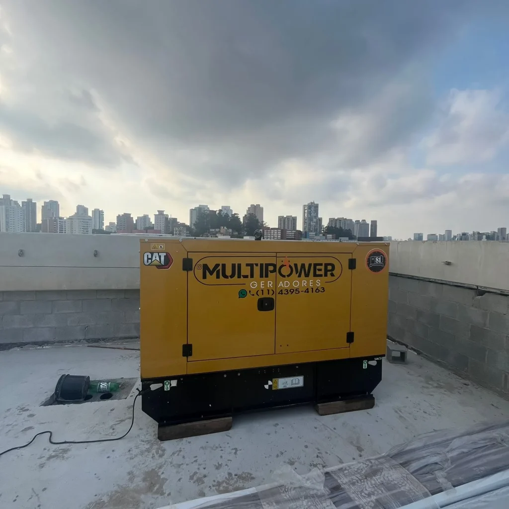 Gerador amarelo sobre laje com edifícios ao fundo.