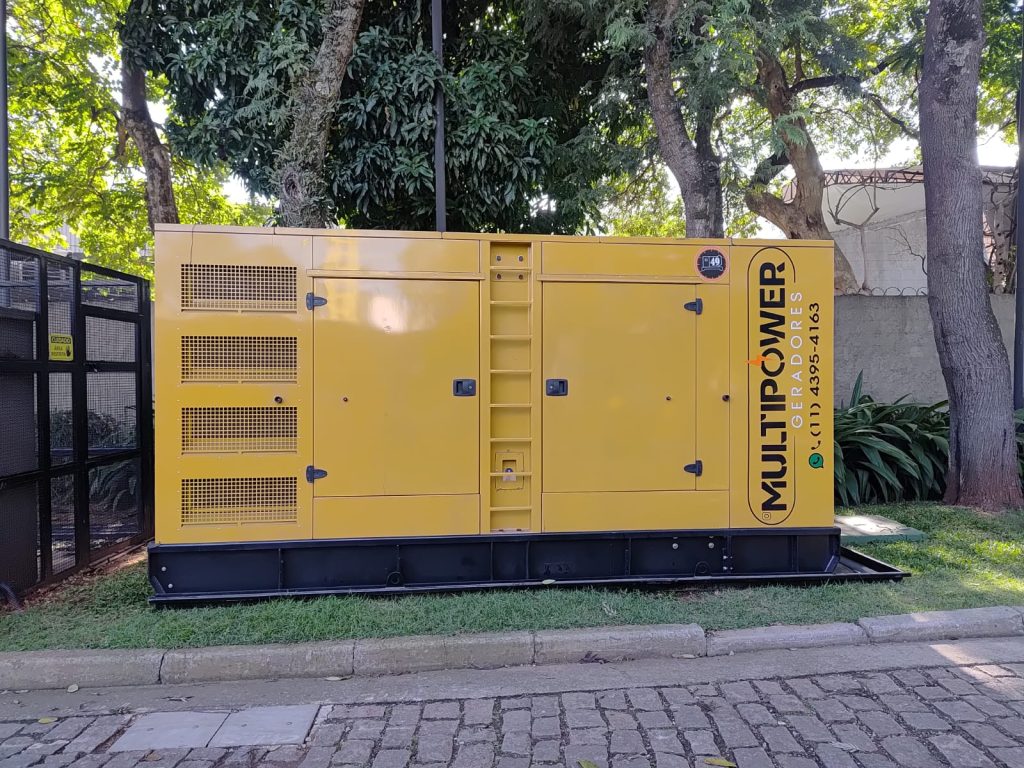 Gerador carenado da MultiPower junto a muro e árvores.