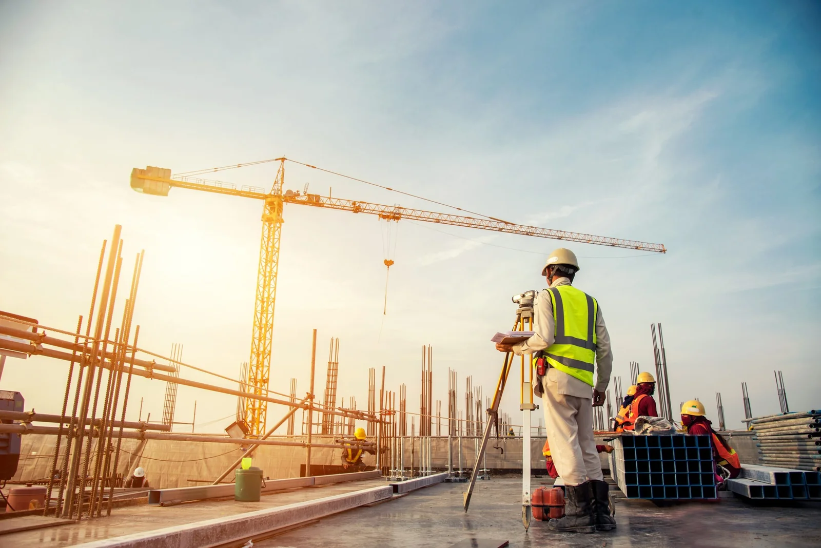 Profissional em canteiro de obras com guindaste.