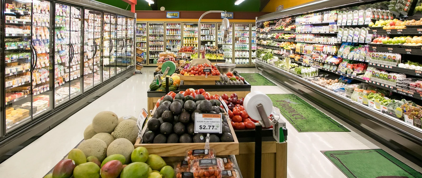 Corredor de supermercado com frutas e prateleiras.